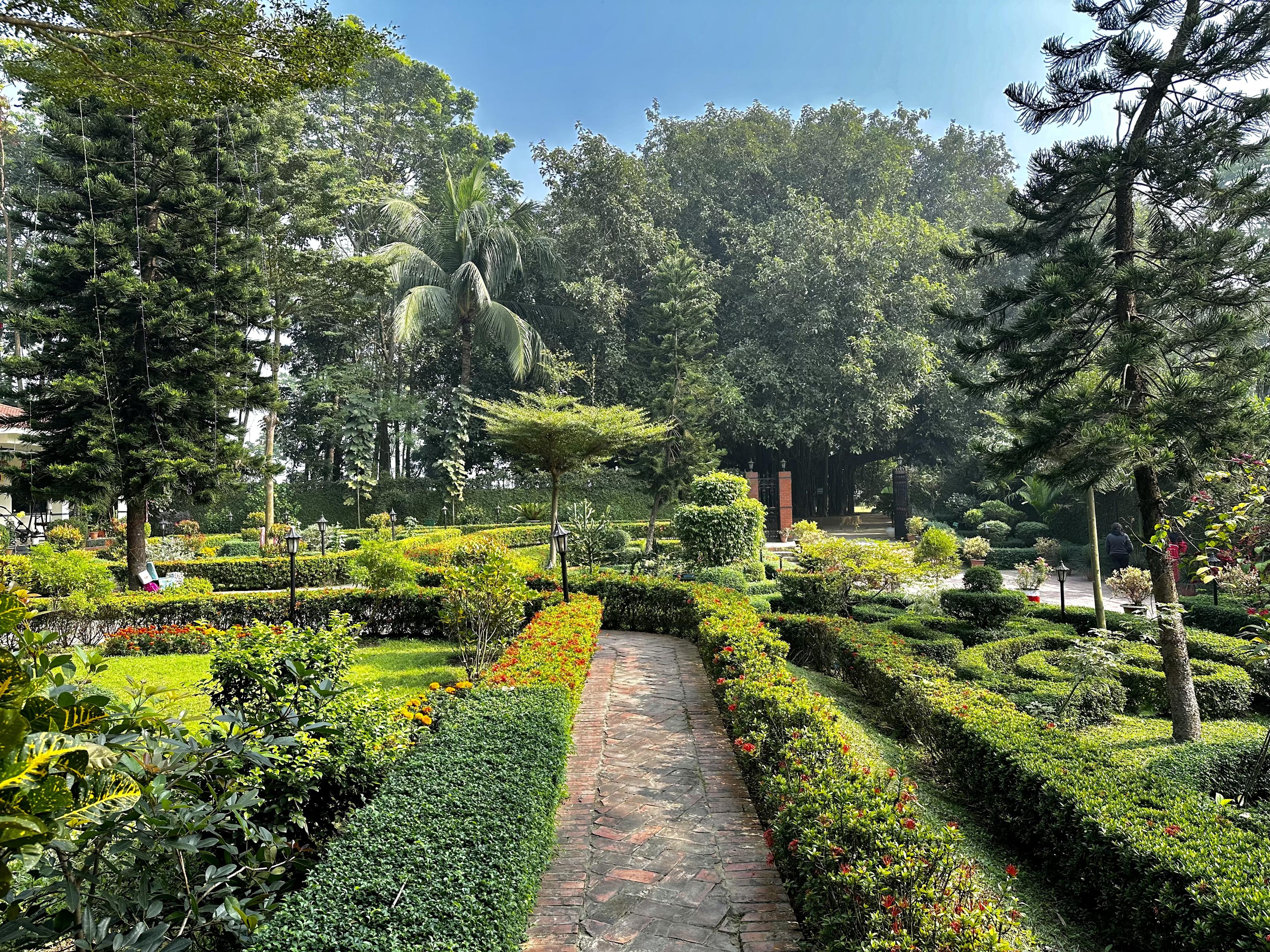 Manicured gardens and intricate hedge pathways at Barnochata Resort Savar Dhaka, echoing the lush landscapes found at Sayeman Beach Resort. বর্ণছটা রিসোর্ট
