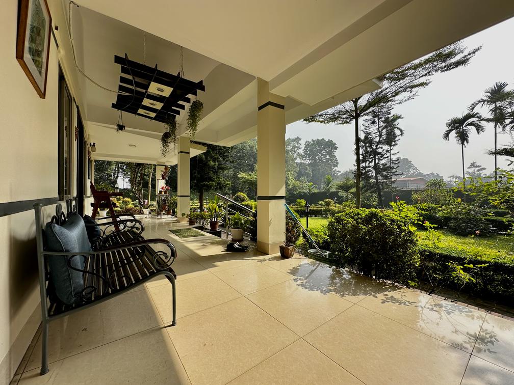 A serene porch with a garden view, featuring a bench. Located at Dhaka Hotel & Resort in Savar, Barnochata. Private cottage available