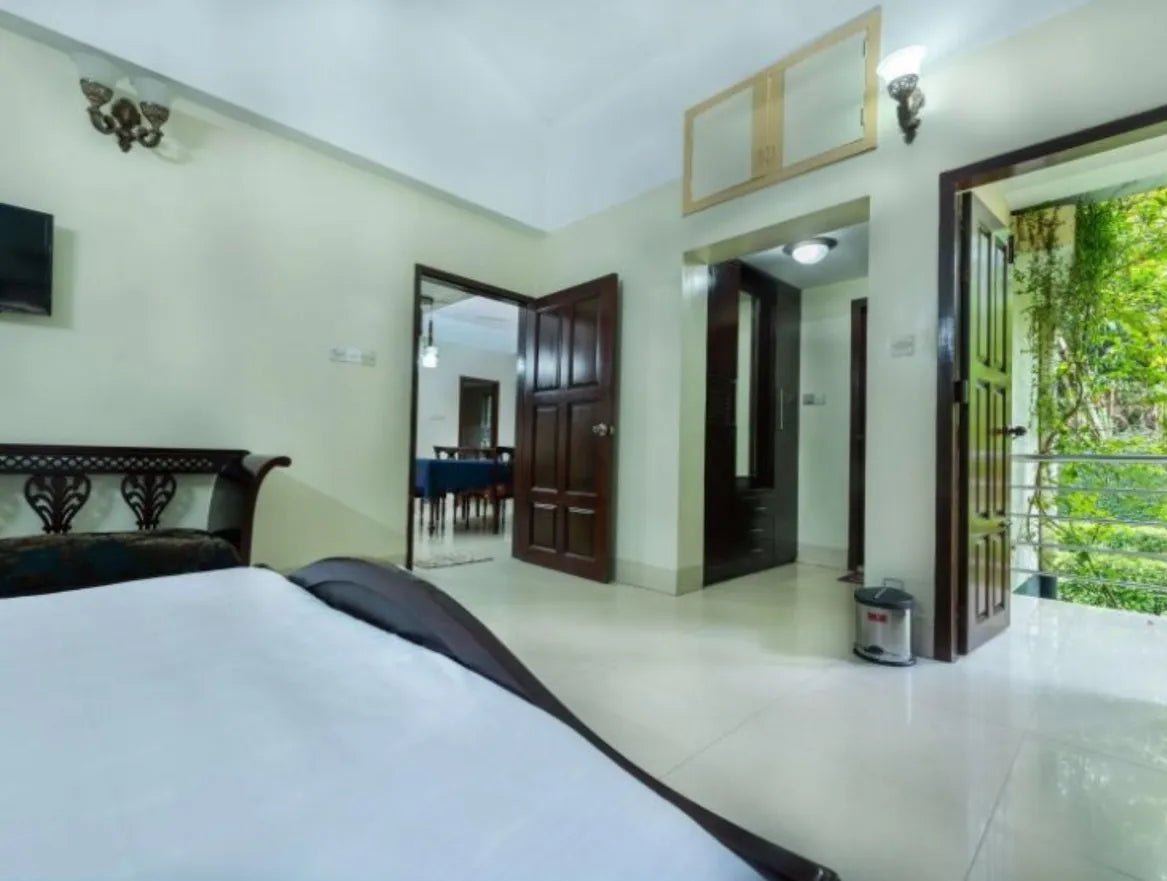An inviting bedroom showcasing a white bed and a television in Dhaka hotel, resort, Savar, Barnochata, private cottage