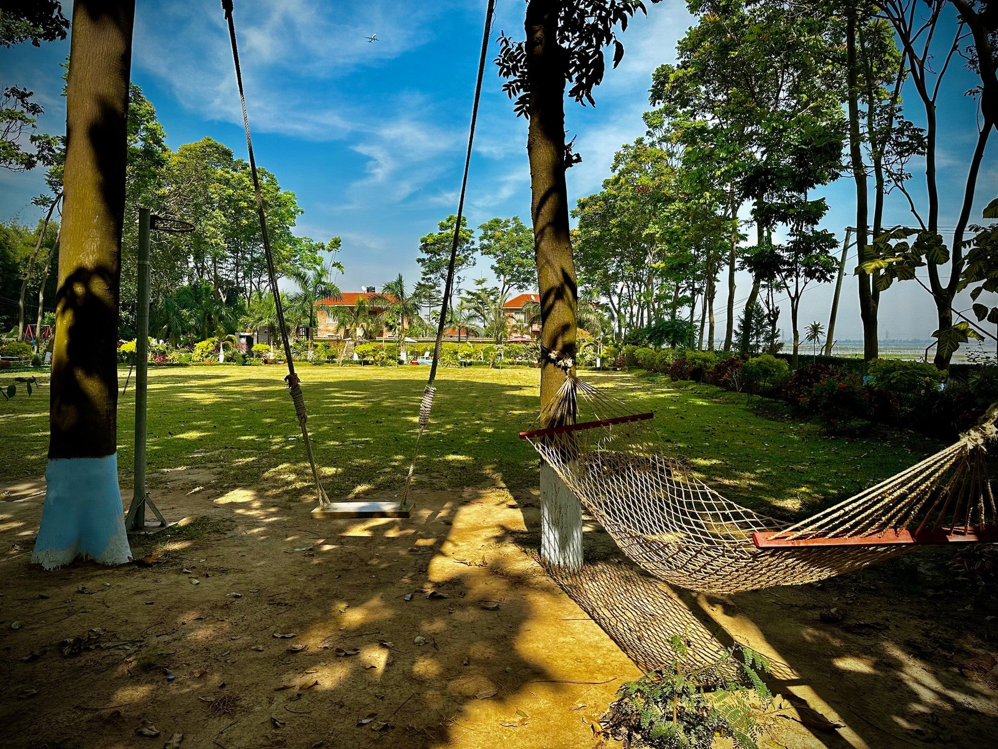 Relaxing hammock and swing set in the peaceful garden area of Barnochata, a resort and Dhaka hotel in Savar, inviting guests to unwind.