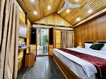 A cozy bedroom with warm wooden walls and ceiling. Located in the Dhaka Hotel resort in Savar, Barnochata.