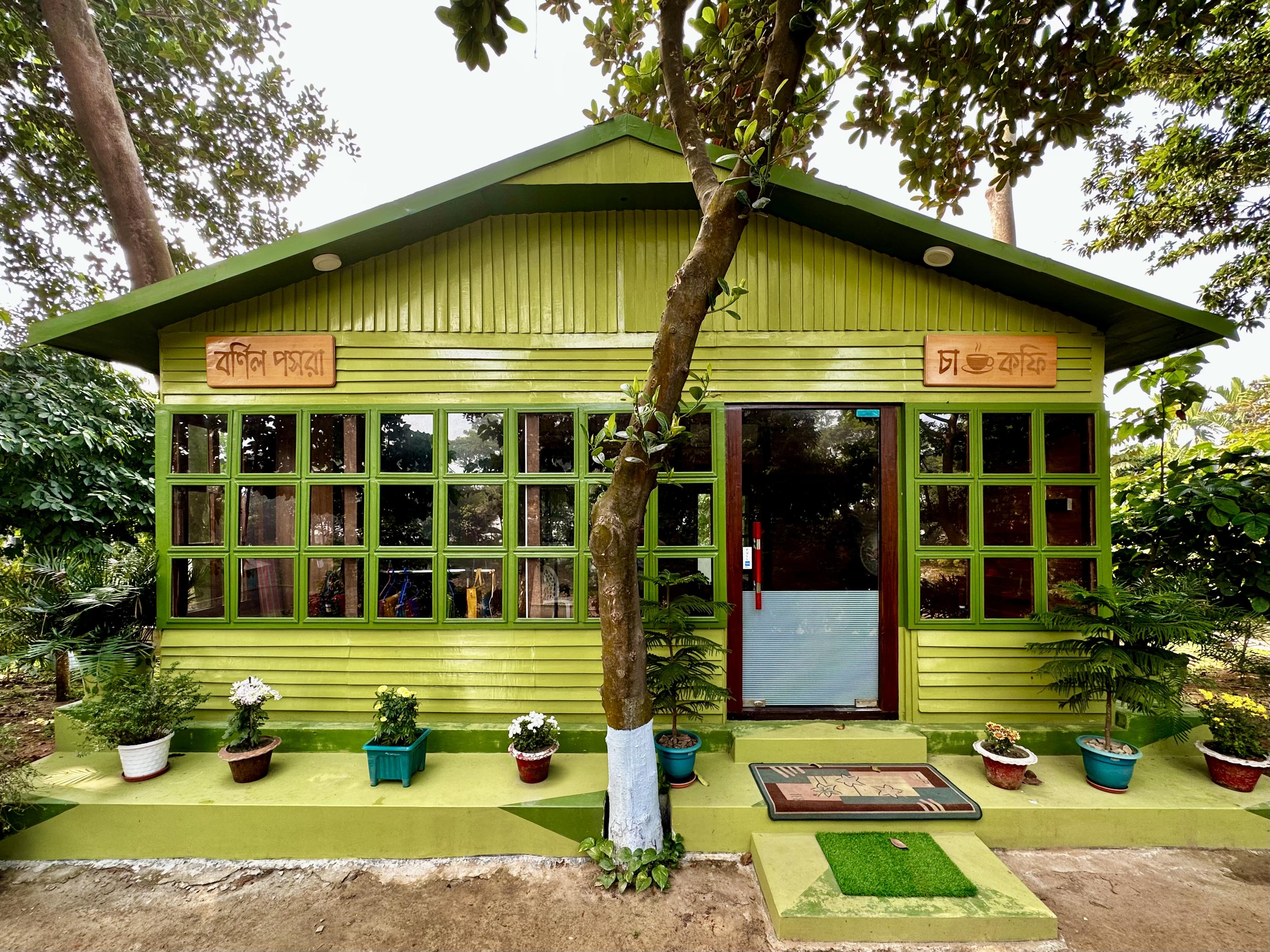 A cozy, green-painted shop and tea cottage nestled among the trees at Barnochata, a picturesque resort and Dhaka hotel in Savar.