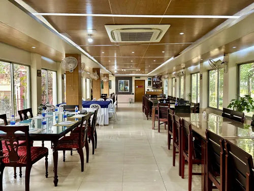 Spacious indoor dining hall with tables and chairs at a resort near Dhaka, Bangladesh বর্ণচ্ছটা রিসোর্ট